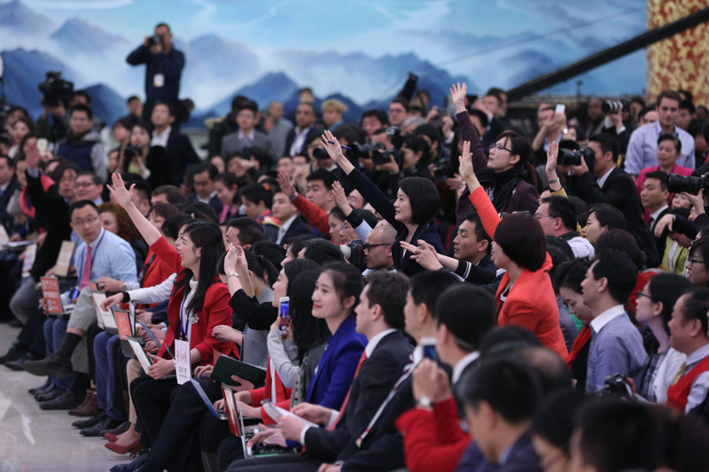 3月15日，國務院總理李克強在北京人民大會堂與中外記者見面，并回答記者提問。這是記者舉手爭取提問機會。 新華社記者 才揚 攝